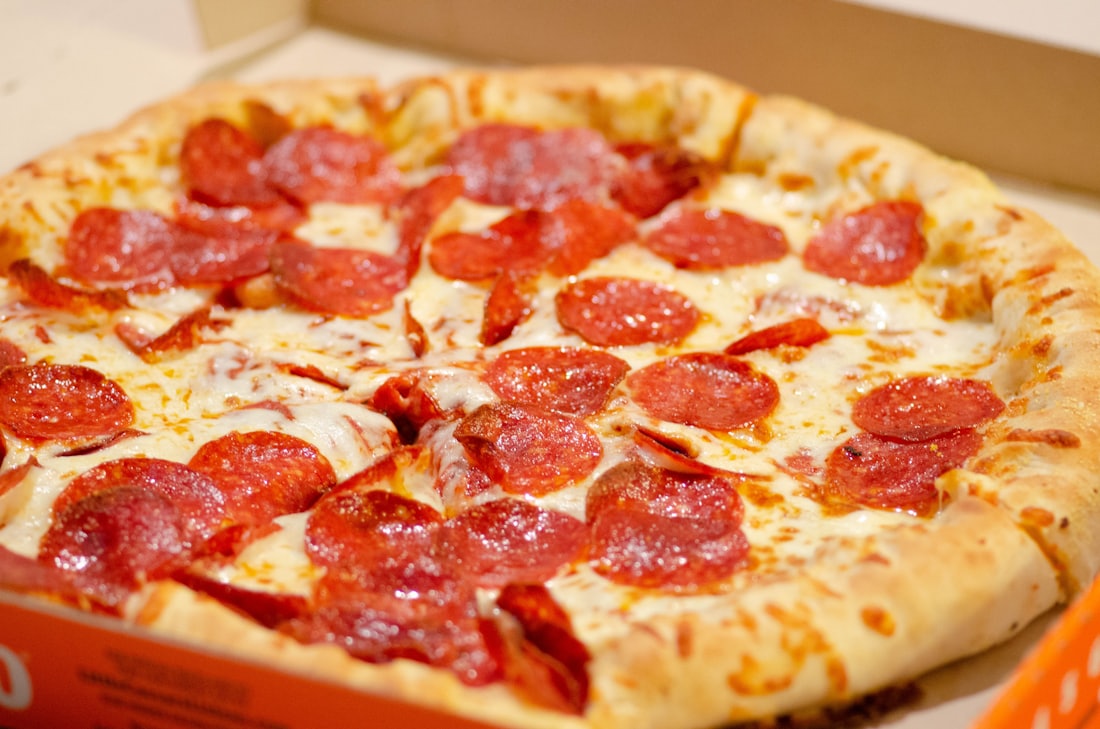 A fresh pepperoni pizza loaded with mozzarella in a takeout box