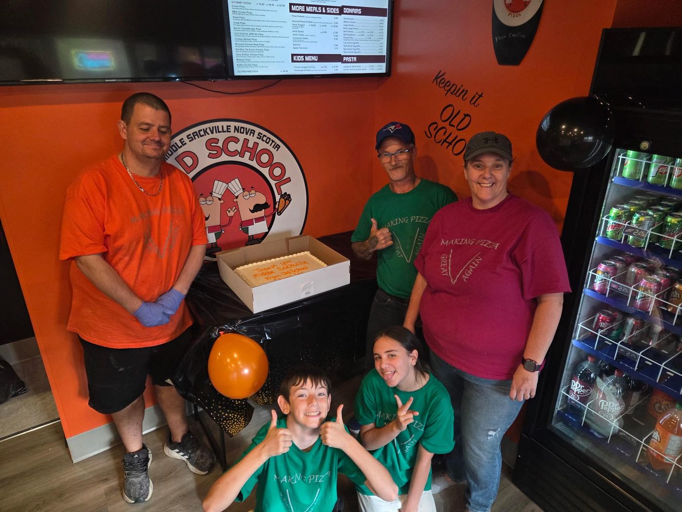 The Old School Pizza crew behind the counter in Middle Sackville with a thank-you cake for the neighbourhood.