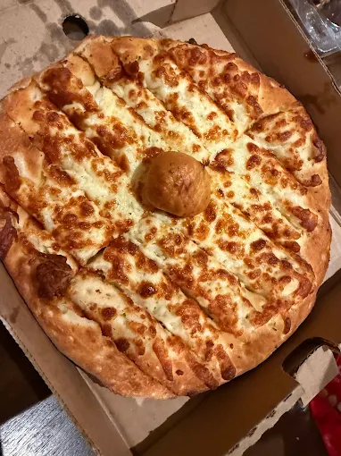 Old School Pizza cheesy garlic fingers in the box with a dip in the centre